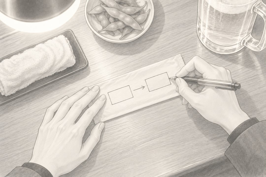 カウンターの上の紙のおしぼりの袋に、女性がボールペンで四角を2つ描き、矢印を引いている手元の寄り（字は読めない線だけ）。